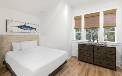 a bedroom with a bed and a dresser and windows at Emerald Tranquility by Oversee 30A in Santa Rosa Beach