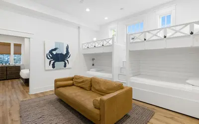 a living room with a couch in front of a bedroom at Emerald Tranquility by Oversee 30A in Santa Rosa Beach