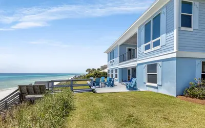 a house with blue chairs and the beach at Family Ties by Oversee 30A in Santa Rosa Beach