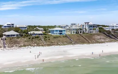 a group of people on the beach in front of houses at Family Ties by Oversee 30A in Santa Rosa Beach