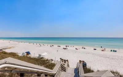 a group of people on a beach with the ocean at Go Coastal by Oversee 30A in Santa Rosa Beach