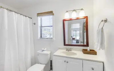 a bathroom with a toilet and a sink and a mirror at Go Coastal by Oversee 30A in Santa Rosa Beach