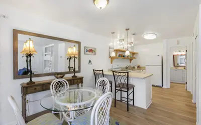 a dining room and kitchen with a glass table and chairs at Go Coastal by Oversee 30A in Santa Rosa Beach