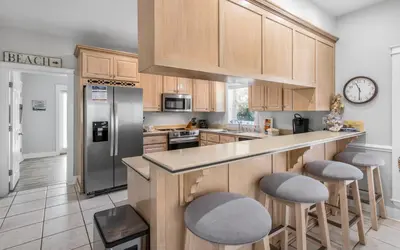 a kitchen with wooden cabinets and stainless steel appliances at Good Life At The C by Oversee 30A in Seacrest