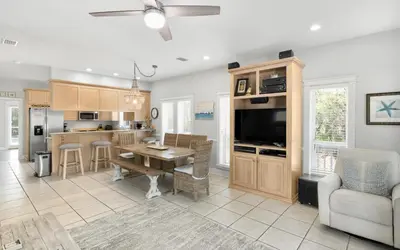 a kitchen and living room with a table and a tv at Good Life At The C by Oversee 30A in Seacrest
