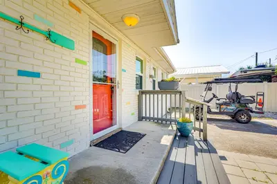 a front porch of a house with a red door at Panama City Home with Fire Pit - Walk to Beaches! in Panama City Beach