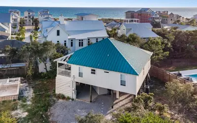 an aerial view of a white house with a blue roof at Hideaway Cottage by Oversee 30A in Inlet Beach