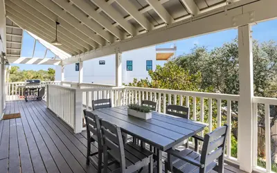 a wooden deck with a table and chairs at Hideaway Cottage by Oversee 30A in Inlet Beach