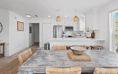 a kitchen and dining room with a table and chairs at Hideaway Cottage by Oversee 30A in Inlet Beach
