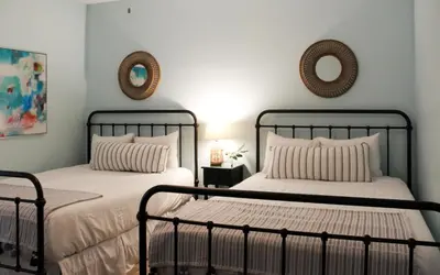 two beds in a bedroom with two mirrors on the wall at High Pointe Unit 1-413 by Oversee 30A in Seacrest