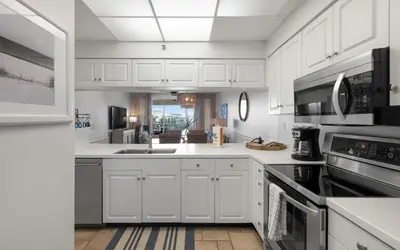 a white kitchen with white cabinets and appliances at High Pointe Unit 1-413 by Oversee 30A in Seacrest