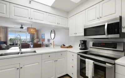 a kitchen with white cabinets and a sink and a microwave at High Pointe Unit 1-413 by Oversee 30A in Seacrest
