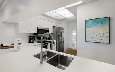 a kitchen with white cabinets and a stainless steel refrigerator at High Pointe Unit 1-413 by Oversee 30A in Seacrest