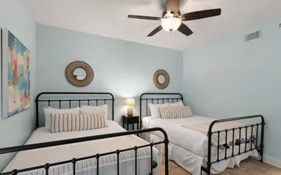 a bedroom with two beds and a ceiling fan at High Pointe Unit 1-413 by Oversee 30A in Seacrest
