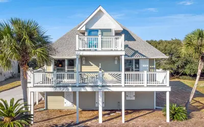 a house with a large deck and palm trees at Holzworth House by Oversee 30A in Santa Rosa Beach