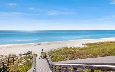 a staircase leading to a beach with the ocean at Holzworth House by Oversee 30A in Santa Rosa Beach