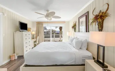 a bedroom with a white bed and a television at Holzworth House by Oversee 30A in Santa Rosa Beach
