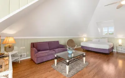 a living room with a bed and a purple couch at Holzworth House by Oversee 30A in Santa Rosa Beach