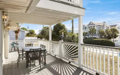 a white porch with a table and chairs on it at Holzworth House by Oversee 30A in Santa Rosa Beach
