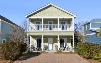 a white house with a porch and a balcony at Inlet Beach Cottage by Oversee 30A in Inlet Beach