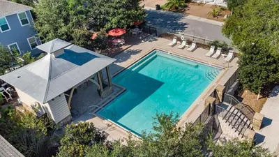 an overhead view of a swimming pool with chairs and a house at Inlet Beach Cottage by Oversee 30A in Inlet Beach
