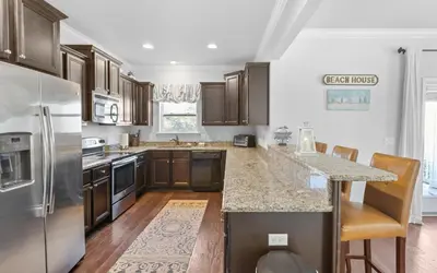 a kitchen with stainless steel appliances and wooden cabinets at Inlet Beach Cottage by Oversee 30A in Inlet Beach