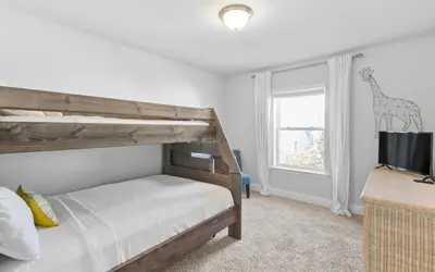 a bedroom with a wooden bunk bed and a television at Inlet Beach Cottage by Oversee 30A in Inlet Beach
