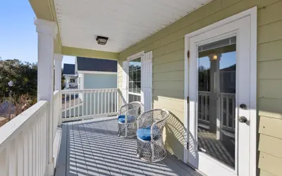 a house with two chairs on the front porch at Inlet Beach Cottage by Oversee 30A in Inlet Beach