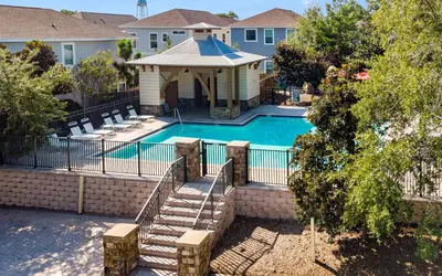 a swimming pool with a fence and stairs next to a house at Inlet Beach Cottage by Oversee 30A in Inlet Beach