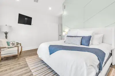 a white bedroom with a bed and a tv on the wall at Inlet Beach Paradise by Oversee 30A in Inlet Beach