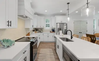 a kitchen with white cabinets and white counter tops at Inlet Beach Paradise by Oversee 30A in Inlet Beach