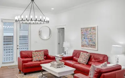 a living room with red furniture and a chandelier at Instant Gratification by Oversee 30A in Santa Rosa Beach