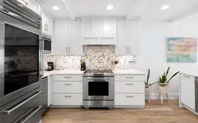 a kitchen with white cabinets and a stove at Into the Mystic by Oversee 30A in Seacrest