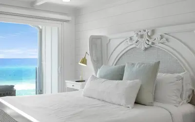 a white bedroom with a bed with a view of the ocean at Into the Mystic by Oversee 30A in Seacrest