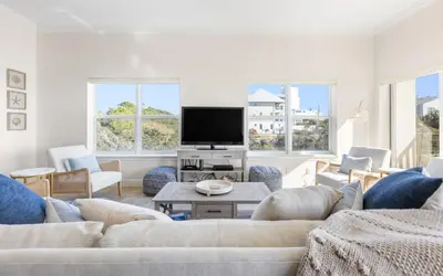 a living room with a couch and a tv at Legacy 201 Emerald Beach by Oversee 30A in Santa Rosa Beach