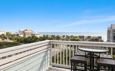a balcony with a table and a view of the ocean at Lemon Squeezy by Oversee 30A in Inlet Beach