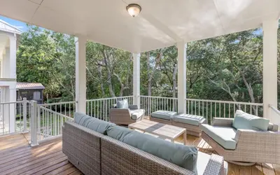 a porch with couches and chairs on a deck at Lofty Oasis by Oversee 30A in Santa Rosa Beach