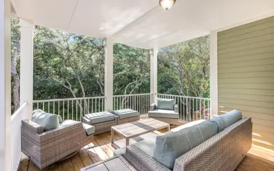a screened porch with couches and a table and chairs at Lofty Oasis by Oversee 30A in Santa Rosa Beach