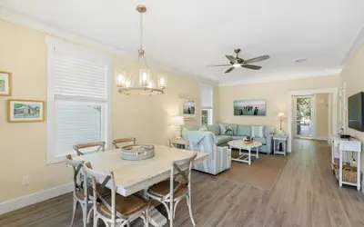 a dining room and living room with a table and chairs at Lofty Oasis by Oversee 30A in Santa Rosa Beach