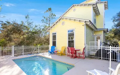 a yellow house with a pool and chairs at Mellow Yellow by Oversee 30A in Santa Rosa Beach