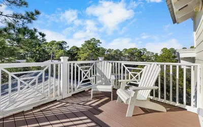 a white railing on a deck with two chairs at Mellow Yellow by Oversee 30A in Santa Rosa Beach