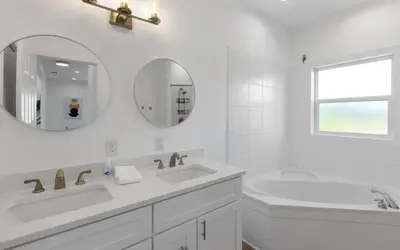 a white bathroom with two sinks and a mirror at Mystic Cottage by Oversee 30A in Inlet Beach