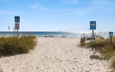 a sandy beach with people in the water at Mystic Cottage by Oversee 30A in Inlet Beach
