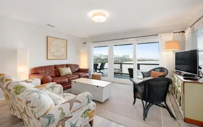 a living room with a couch and a tv at Noras Place by Oversee 30A in Santa Rosa Beach
