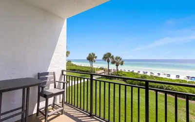a balcony with a table and chairs and the beach at Palms of Seagrove A8 by Oversee 30A in Santa Rosa Beach