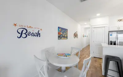 a kitchen with a white table and chairs in a room at Palms of Seagrove A8 by Oversee 30A in Santa Rosa Beach