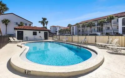 a swimming pool with chairs and a fence at Palms of Seagrove A8 by Oversee 30A in Santa Rosa Beach