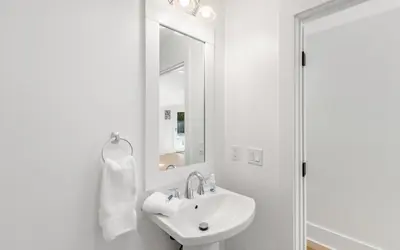 a white bathroom with a sink and a mirror at Palms on Pelican by Oversee 30A in Seacrest