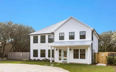 a white house with black windows and a fence at Palms on Pelican by Oversee 30A in Seacrest