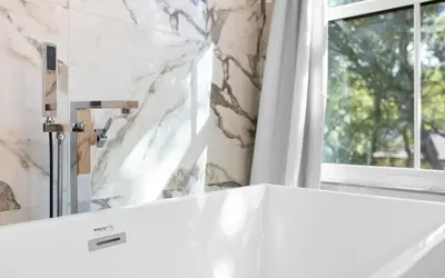 a bathroom with a white counter and a window at Palms on Pelican by Oversee 30A in Seacrest